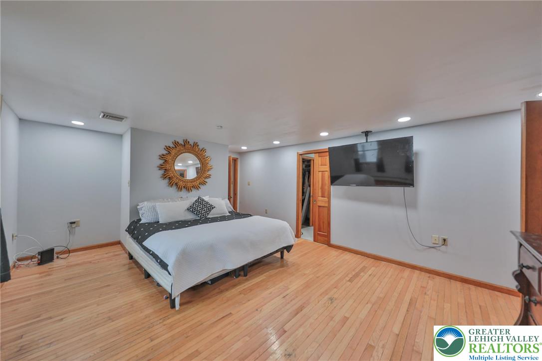 257 Hoffman Road Wind Gap, PA 18091 - Photo 5 of 52 a spacious bedroom with a bed and a dresser with wooden floor