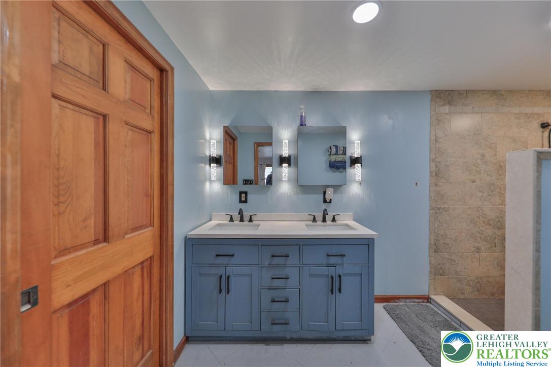 257 Hoffman Road Wind Gap, PA 18091 - Photo 7 of 52 a bathroom with a granite countertop sink a mirror and a shower