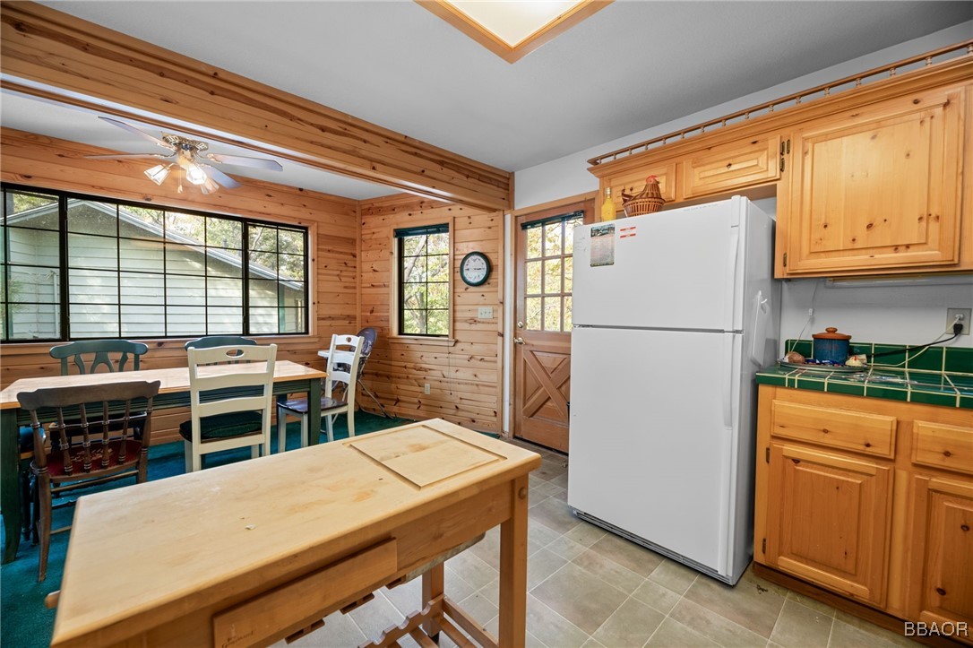 1464 Rockspray Drive Big Bear Lake, CA 92315 - Photo 11 of 26 a kitchen with a refrigerator a stove top oven and a dining table