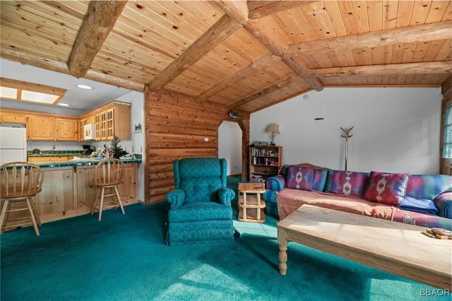 a living room with furniture and a view of kitchen