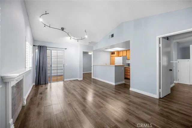 a view of a big room with wooden floor and windows