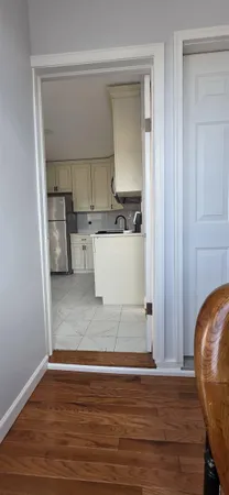 a view of a kitchen with wooden floor and electronic appliances