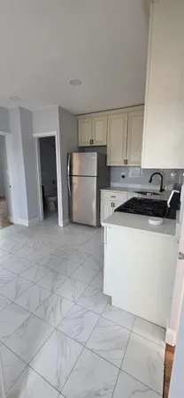 a kitchen with a sink a refrigerator and cabinets