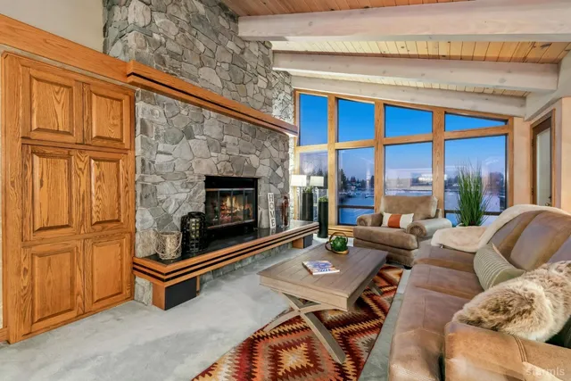 a living room with furniture a fireplace and a floor to ceiling window
