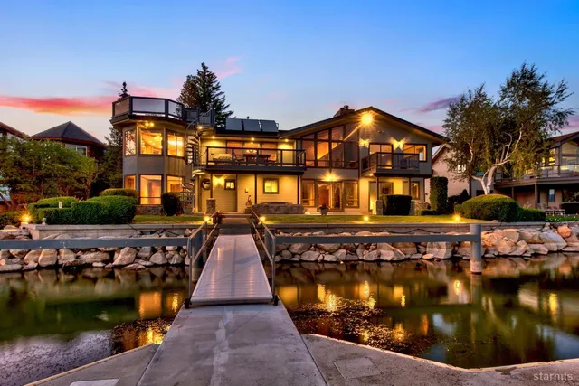 a view of a lake in front of a house with a yard