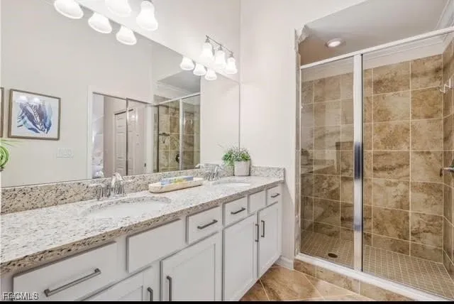 a bathroom with a granite countertop sink a mirror and a shower