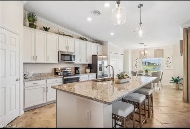 a kitchen with kitchen island granite countertop stainless steel appliances cabinets a sink and a island
