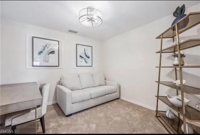 a living room with furniture a dining table and a chandelier
