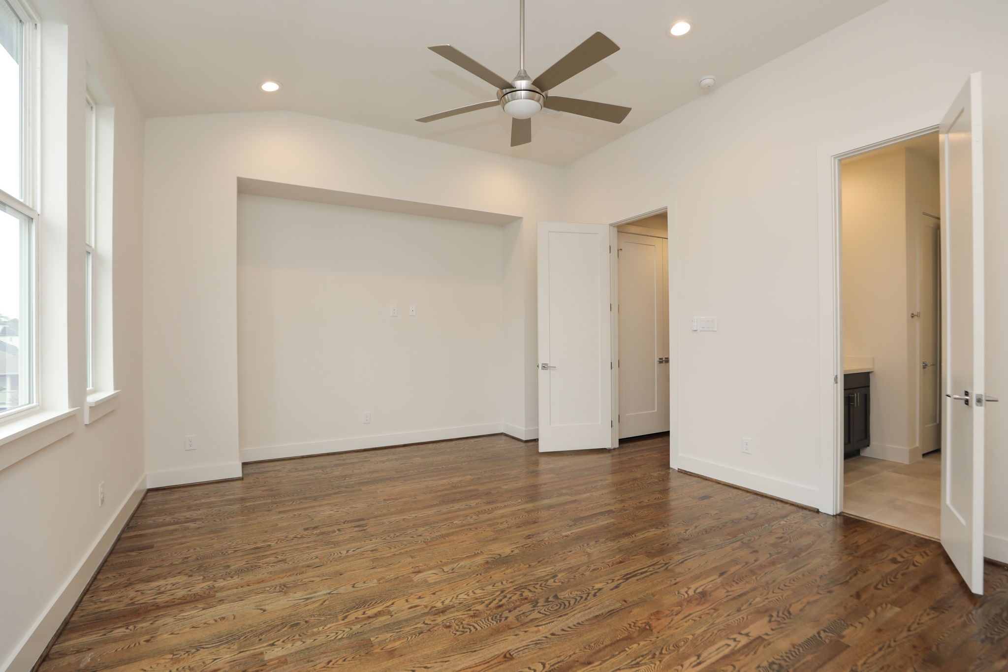 1537 West 24th Street, Unit C Houston, TX 77008 - Photo 27 of 34 an empty room with wooden floor and a ceiling fan