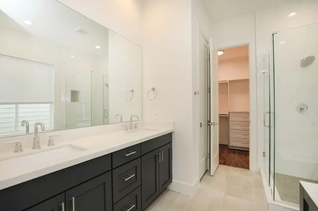 a bathroom with a double vanity sink mirror and shower