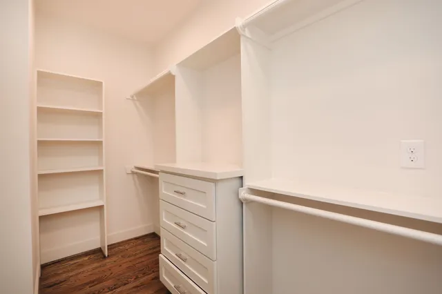 a view of walk in closet with empty racks
