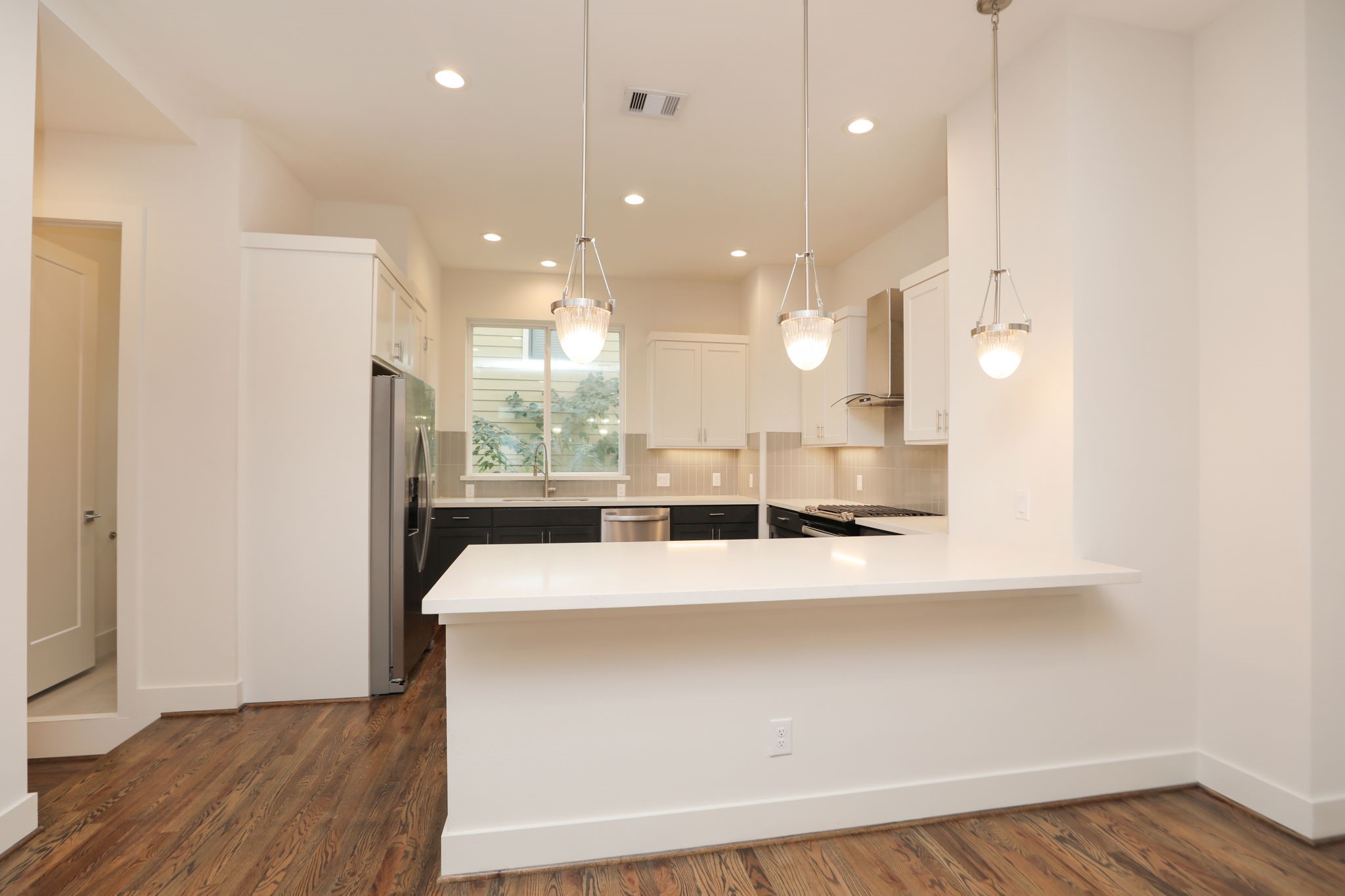 1537 West 24th Street, Unit C Houston, TX 77008 - Photo 8 of 34 a large white kitchen with a large island oven a stove with kitchen island