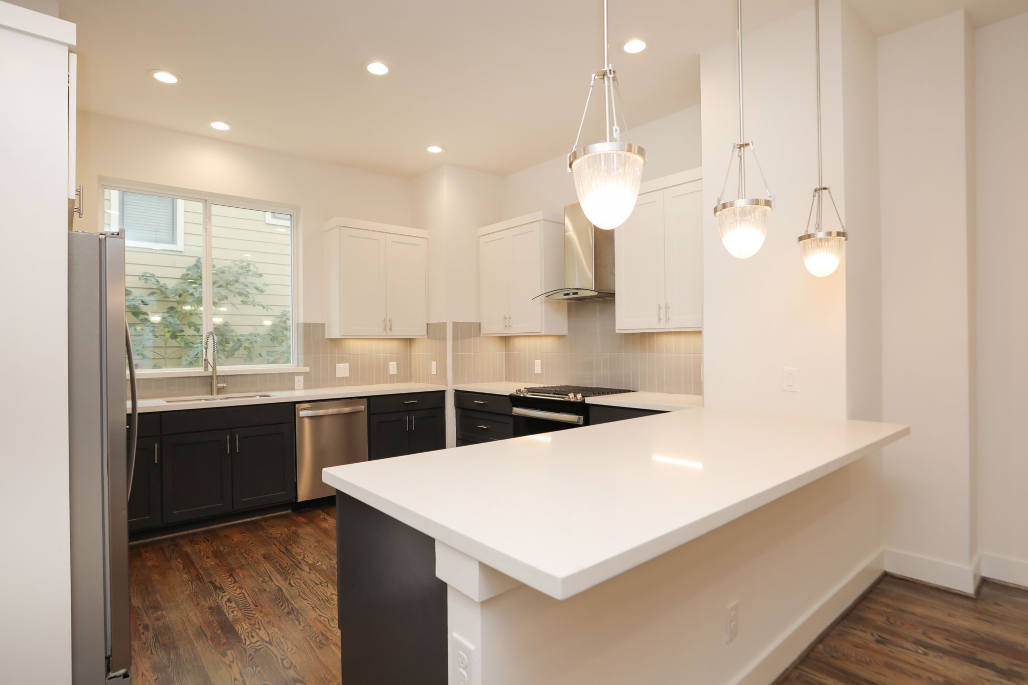 1537 West 24th Street, Unit C Houston, TX 77008 - Photo 9 of 34 a kitchen with a refrigerator a sink and dishwasher with wooden floor