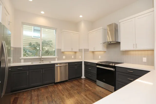 a kitchen with stainless steel appliances granite countertop a stove a sink and a microwave