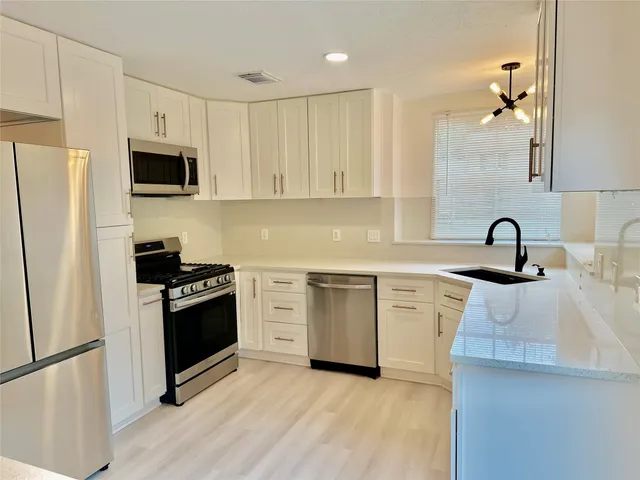 a kitchen with granite countertop a sink and stainless steel appliances