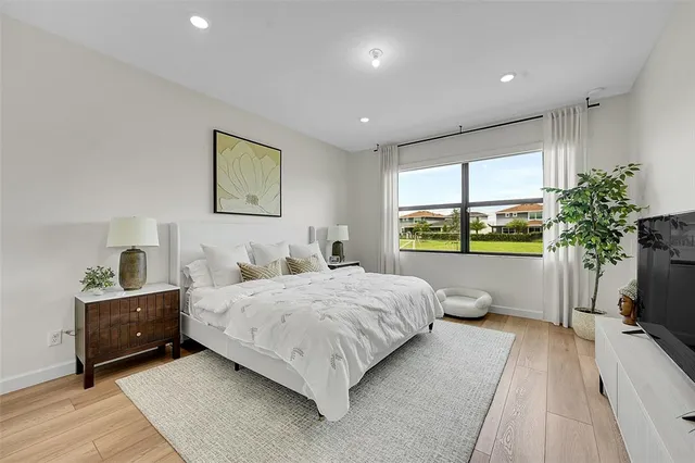a bedroom with a large bed and a potted plant