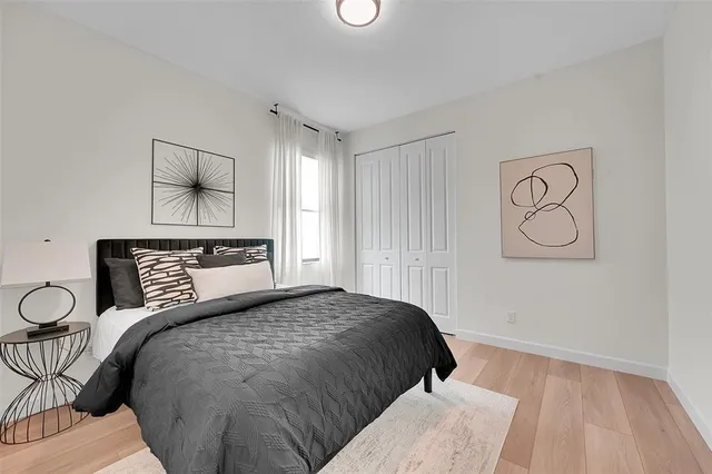 a bedroom with a bed and wooden floor