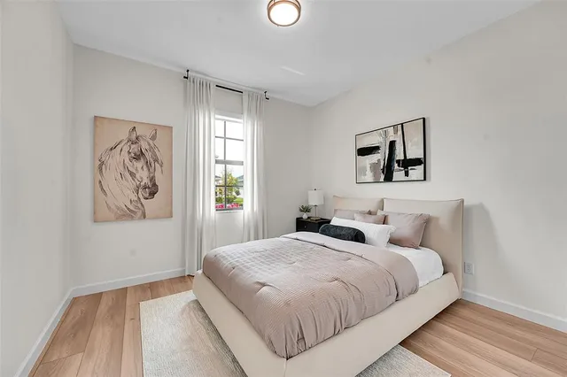 a bedroom with a bed and painting on the wall