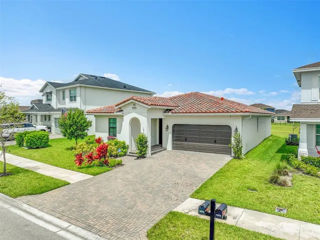 an aerial view of a house with a garden and lake view