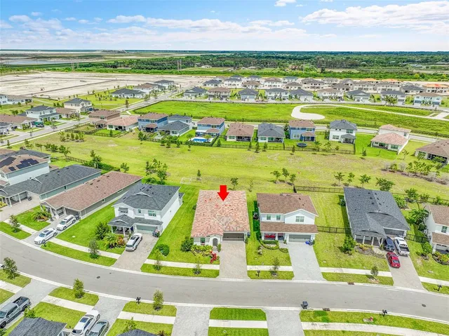 a childrens park with lots of swings slides and swimming pool in the back