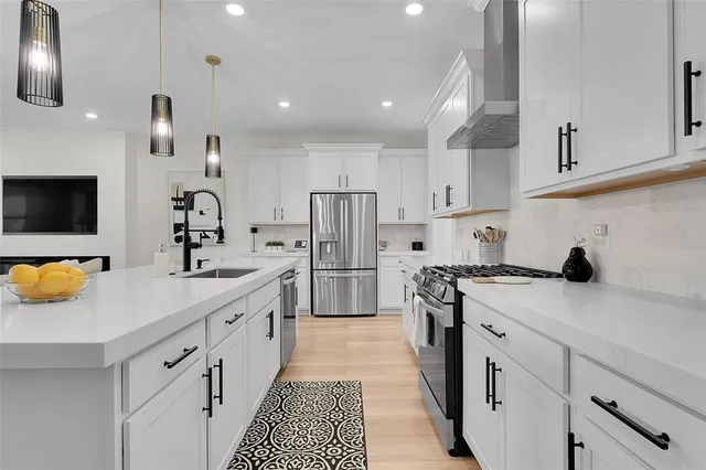 a kitchen with stainless steel appliances a sink stove and refrigerator