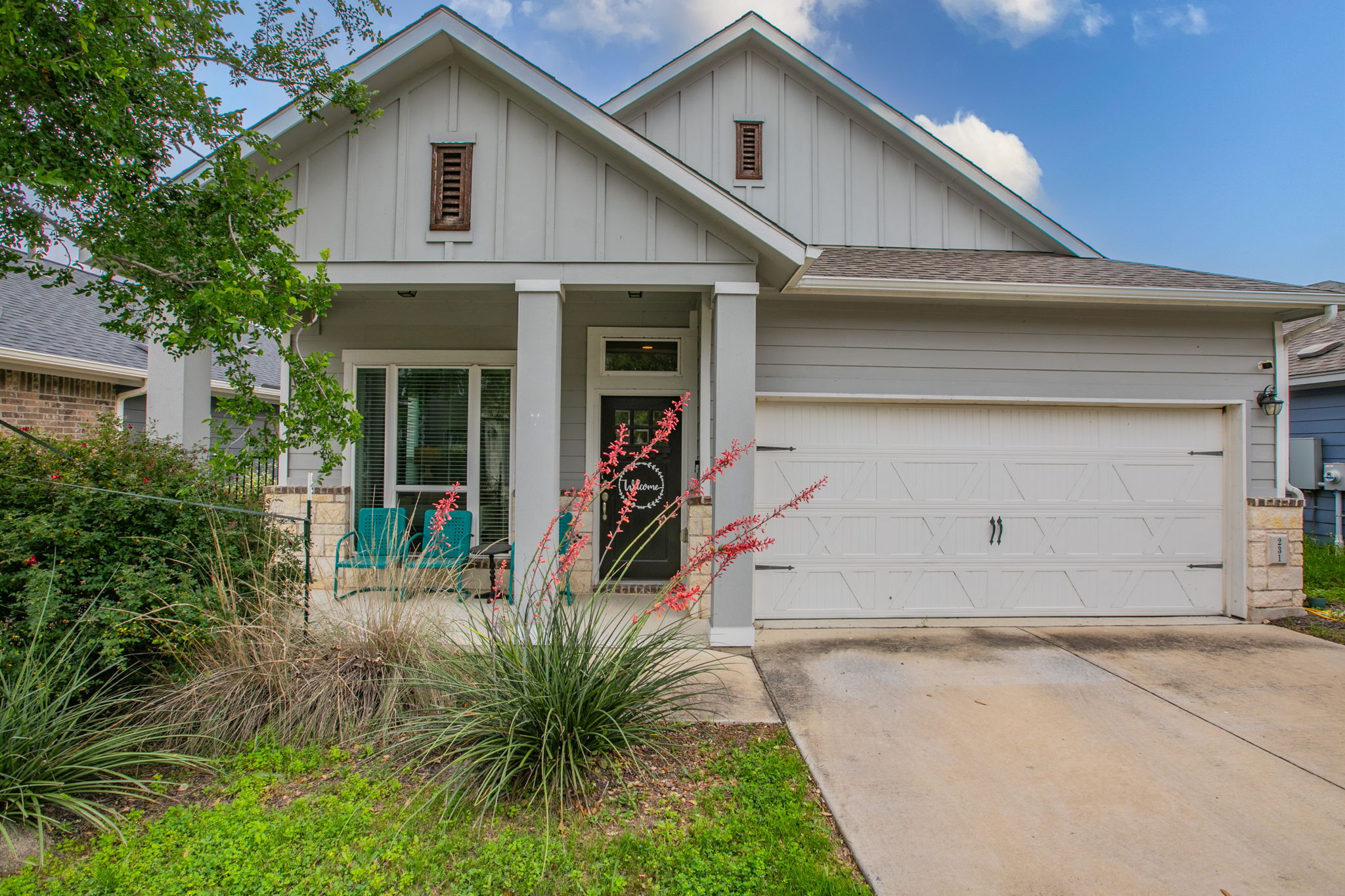 231 Simon Kyle, TX 78640 - Photo 1 of 29 Contemporary grey siding exterior with a covered porch, an attached garage, and a concrete driveway