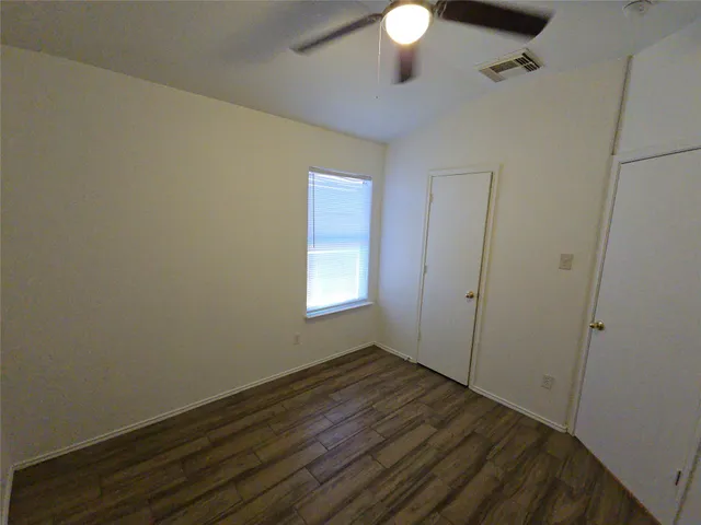 a view of a room with wooden floor and fan