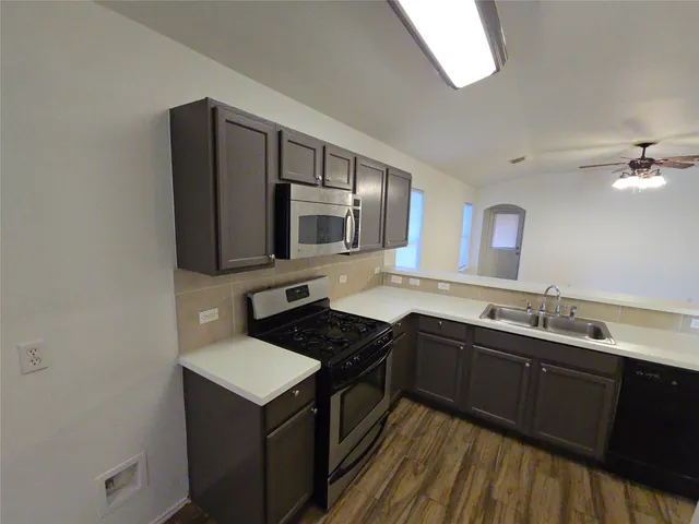 a kitchen with a sink stove and microwave