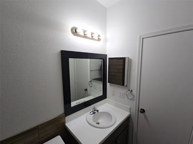 a bathroom with a sink vanity and mirror