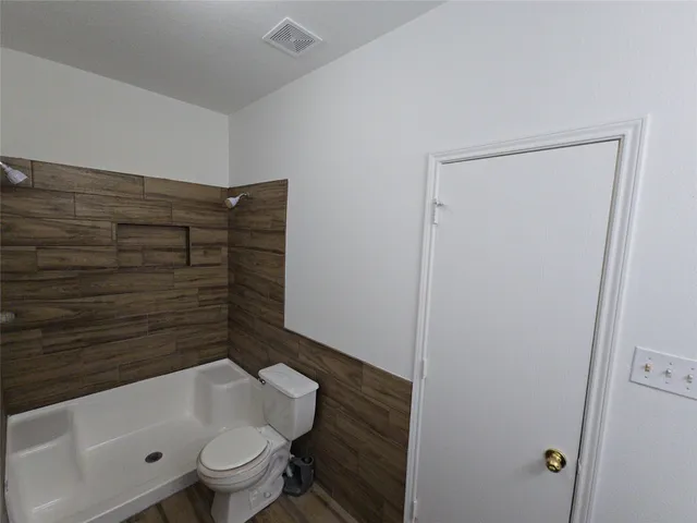 a bathroom with a toilet and a shower