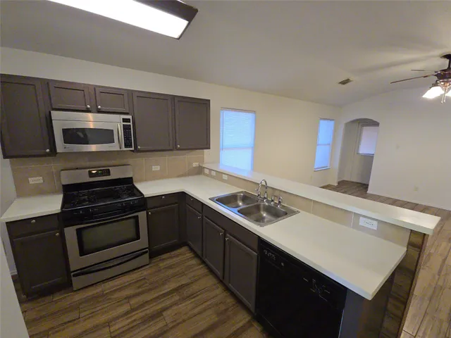 a kitchen with a stove a sink and a microwave