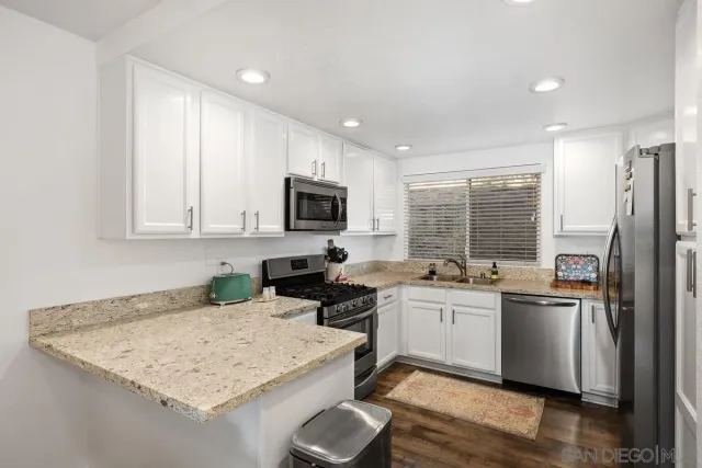 a kitchen with a sink a stove a refrigerator and cabinets