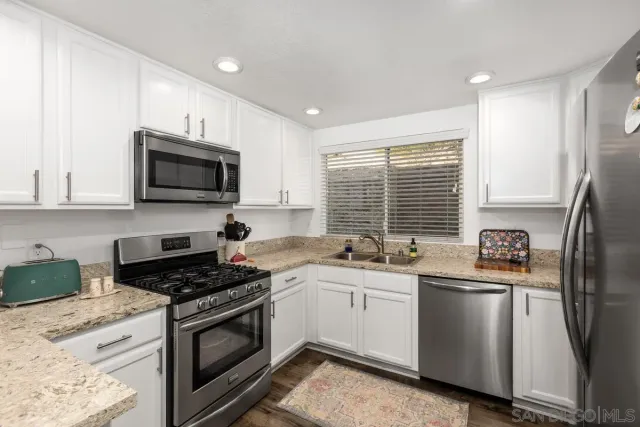 a kitchen with stainless steel appliances a sink stove and microwave