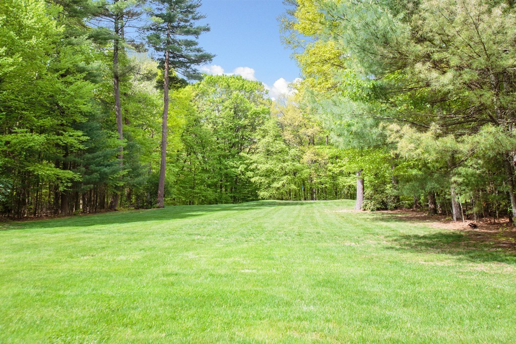 144 Sandy Pond Road Lincoln, MA 01773 - Photo 30 of 30 a view of a grassy field with trees in the background