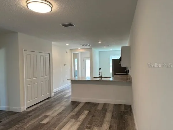 a view of a kitchen with wooden floor and a sink