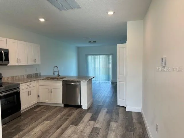 a kitchen with wooden floors and white appliances