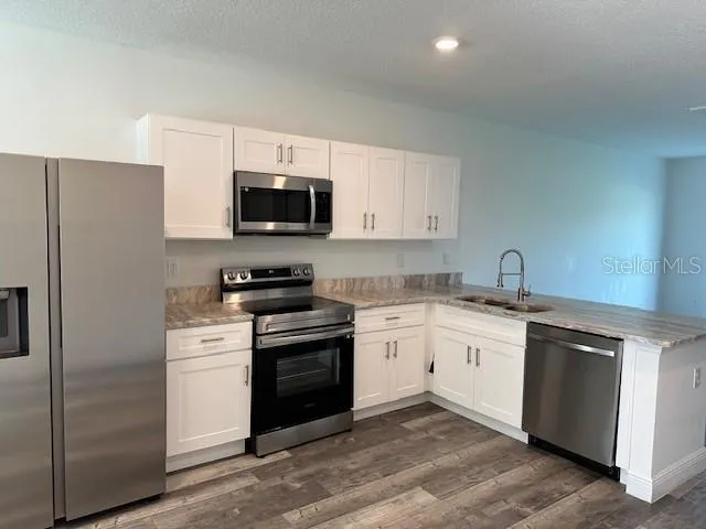 a kitchen with stainless steel appliances granite countertop a stove top oven a sink and dishwasher