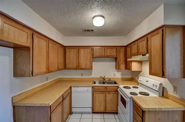a kitchen that has a sink and a stove in it
