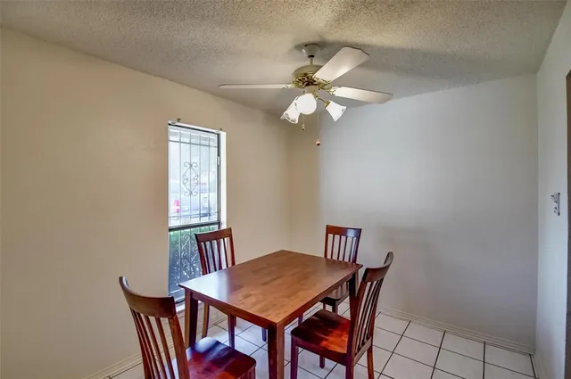 a view of a dining room with furniture and a chandelier fan