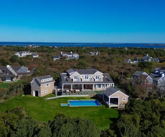 an aerial view of a house with a lake