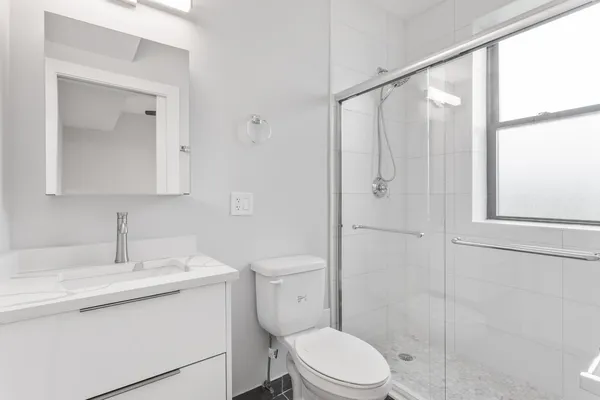 a bathroom with a toilet a sink a vanity and mirror
