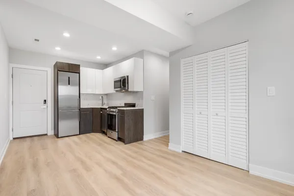 a kitchen with stainless steel appliances kitchen island a refrigerator sink and cabinets