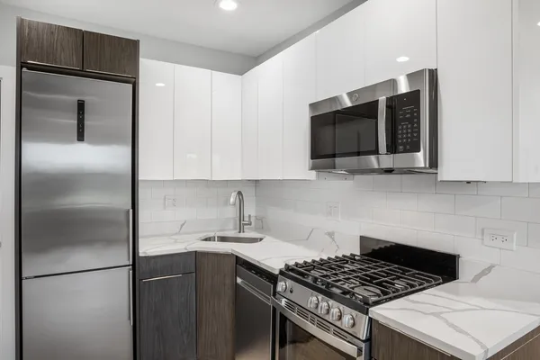 a kitchen with stainless steel appliances granite countertop a stove a refrigerator and a microwave