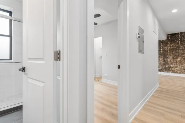 a view of a hallway with wooden floor and staircase