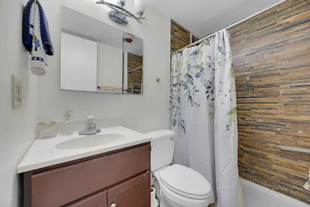 a bathroom with a sink a toilet and shower curtain