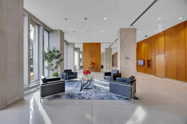 a living room with furniture potted plant and a large window