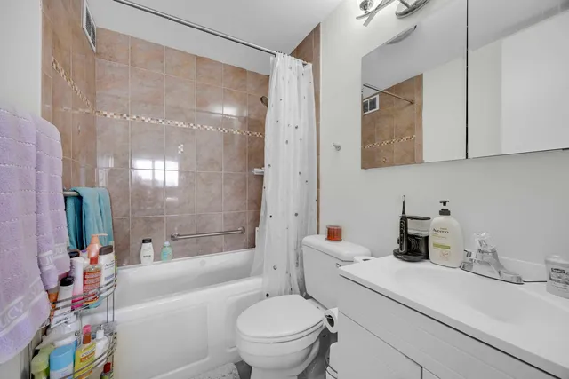 a bathroom with a sink a toilet a mirror and shower
