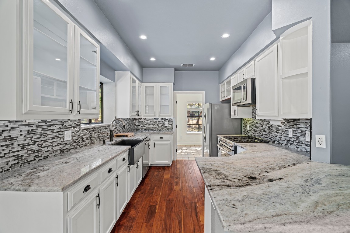 128 Mockingbird Lane Georgetown, TX 78633 - Photo 8 of 40 a large kitchen with stainless steel appliances kitchen island granite countertop a sink and cabinets