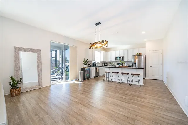 a view of a kitchen with dining table chairs wooden floor and windows