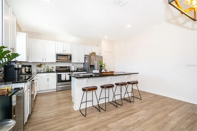 a kitchen with a sink cabinets and wooden floor